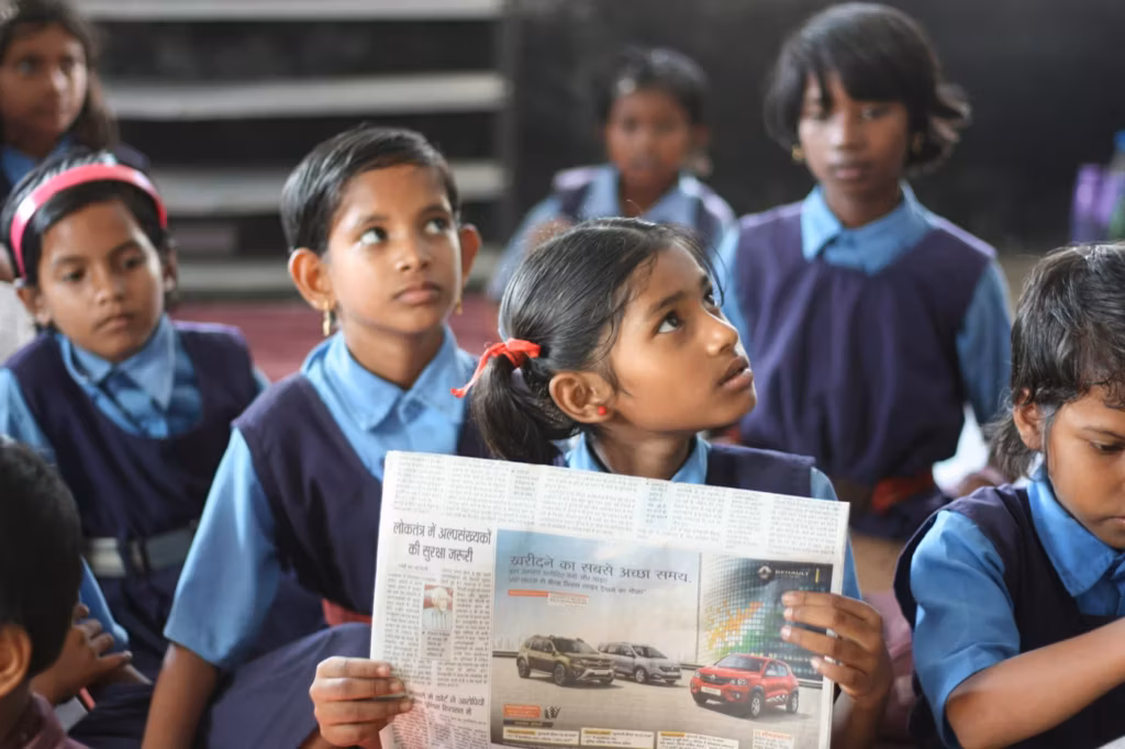A schoolgirl reading a newspaper with her classmates