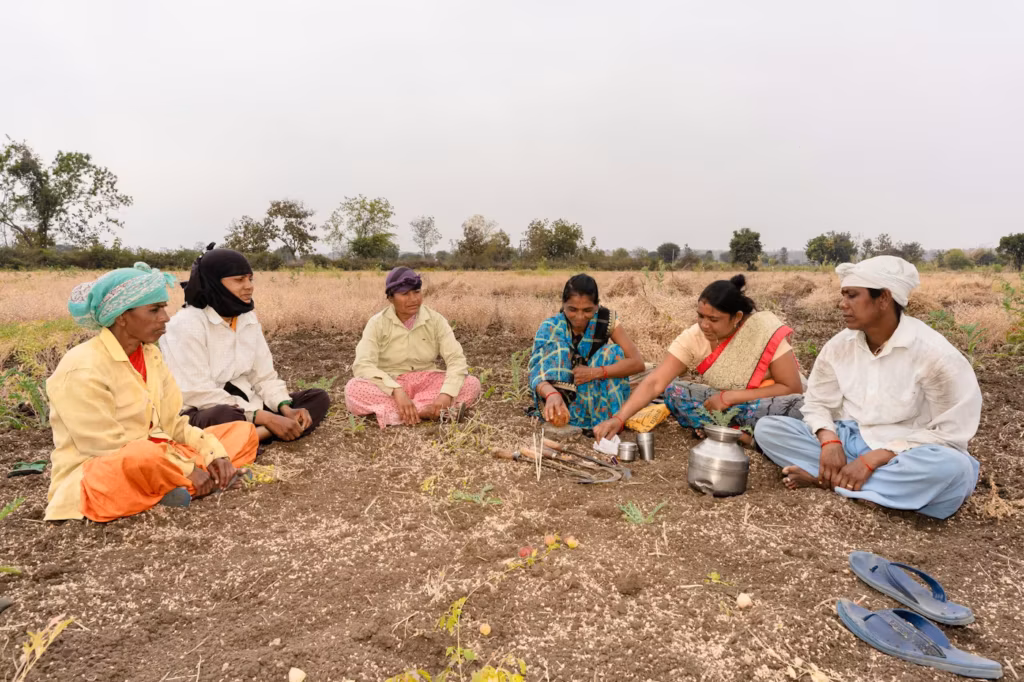 Villagers sitting in a field for a group discussion
