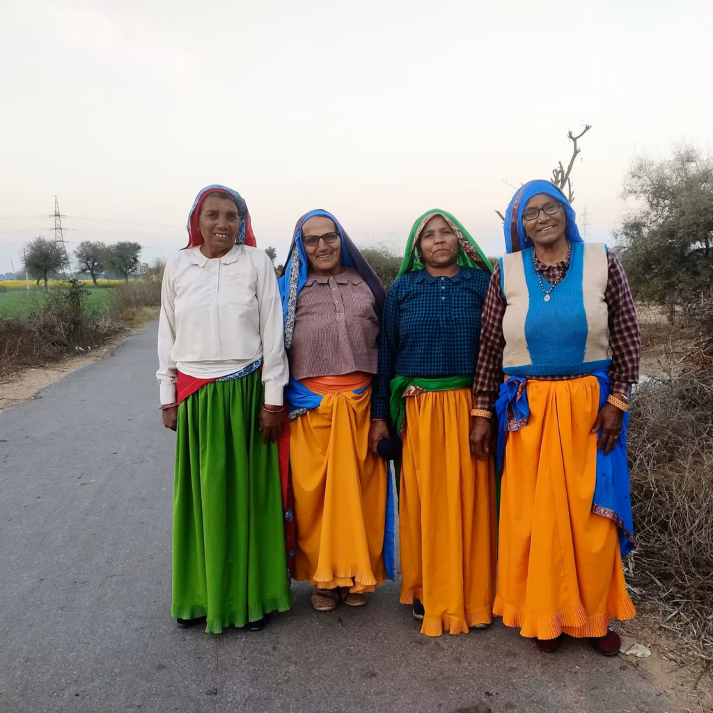 Four elderly women standing together on a village road
