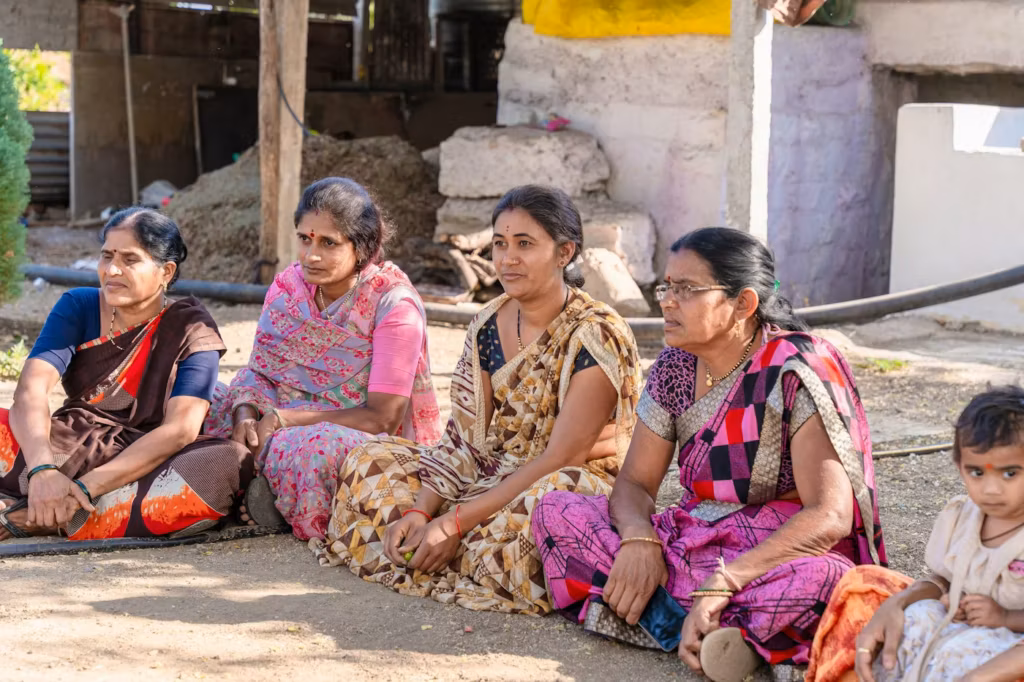 Women of the village sitting together outside a home